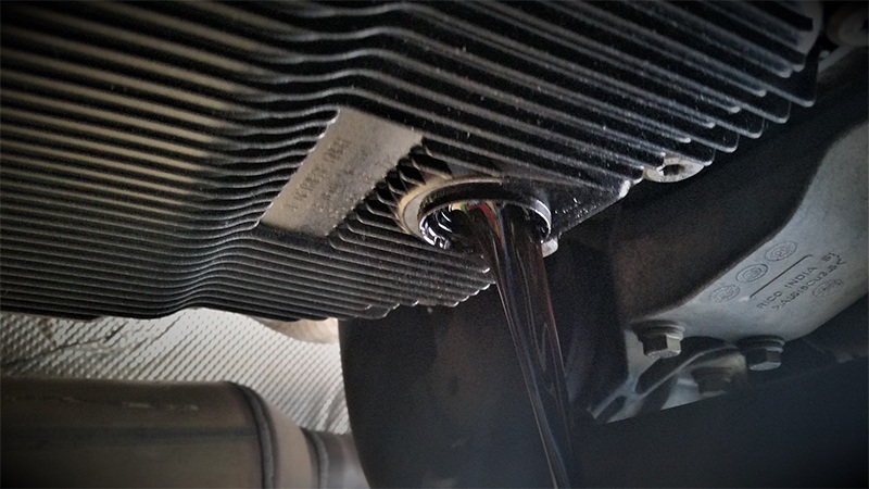 Locate the drain plug, and loosen it using a 10 mm hex bit. Then remove the oil pan bolts with a T40 torx bit.